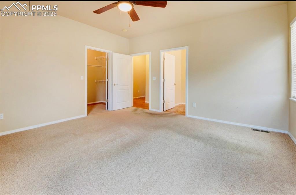 Image 35 of 42: Unfurnished bedroom featuring light colored carpet, a walk in closet, and c