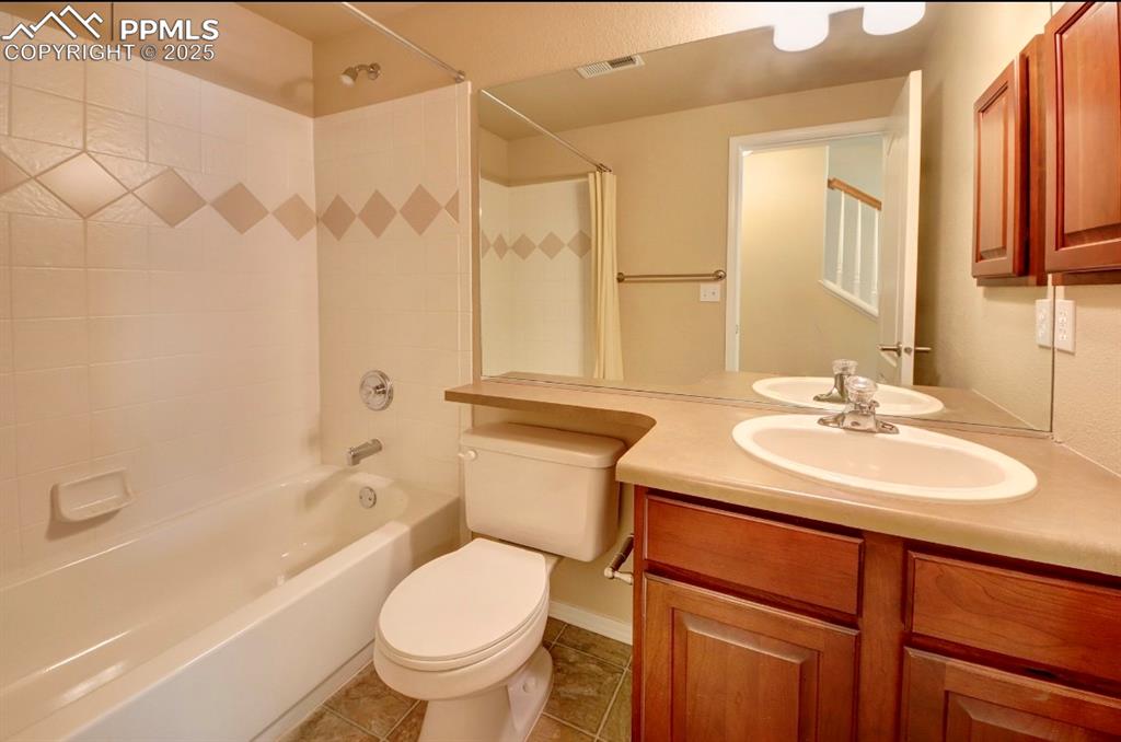 Image 37 of 42: Bathroom featuring shower / bathtub combination, vanity, and light tile pat