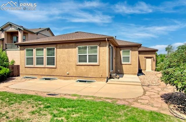 Image 41 of 42: Rear view of house featuring stucco siding and roof with shingles