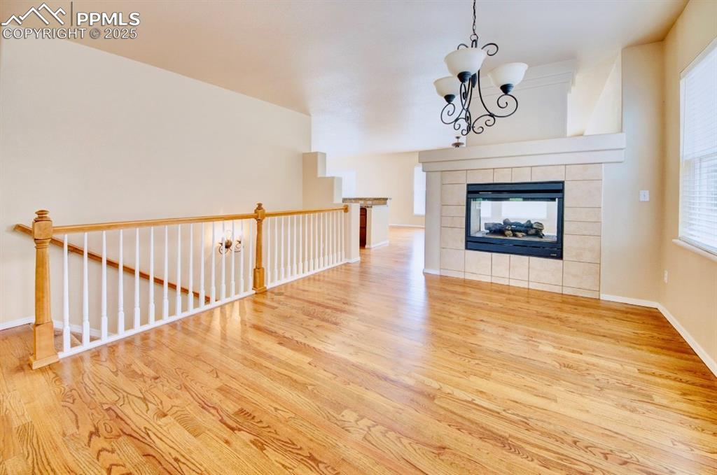 Image 5 of 42: Unfurnished living room featuring a tile fireplace, light wood-type floorin