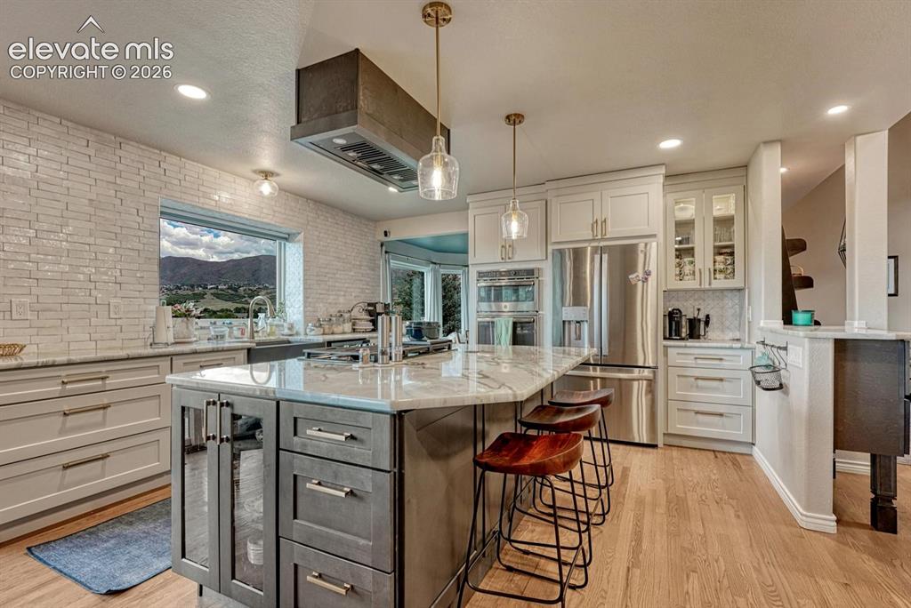 Image 12 of 41: Gourmet kitchen with stainless steel appliances, large center island with s
