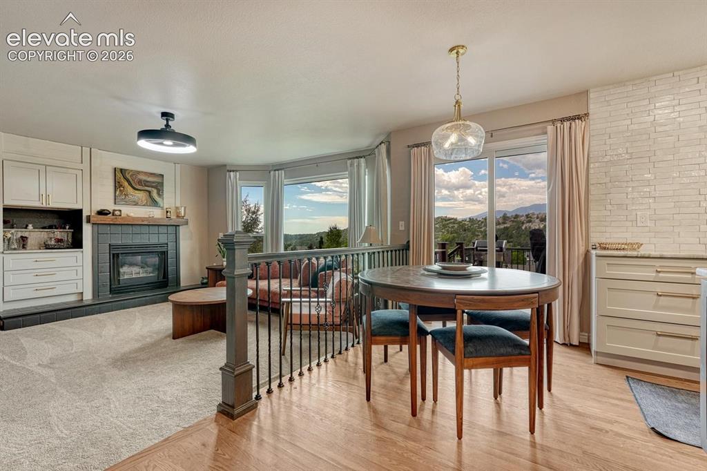 Image 14 of 41: Built-in cabinetry, tiled fireplace with hearth, bay windows, sliding glass