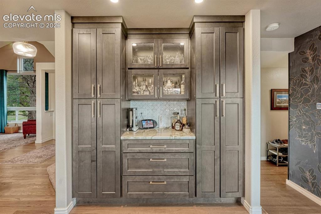 Image 15 of 41: Built-in cabinetry with glass-front uppers, a light-toned countertop, and t