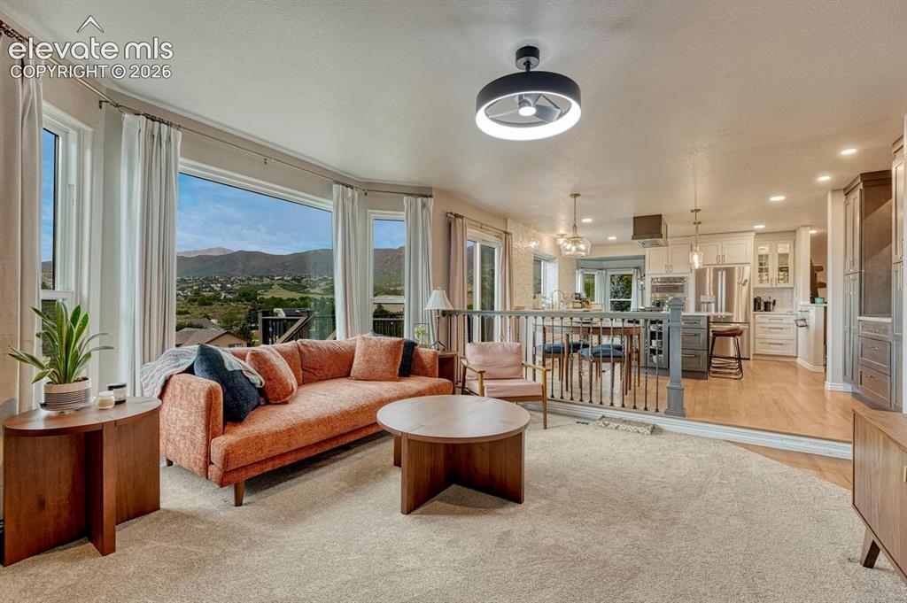 Image 17 of 41: Expansive window array, contemporary ceiling fan, recessed lighting, wood f