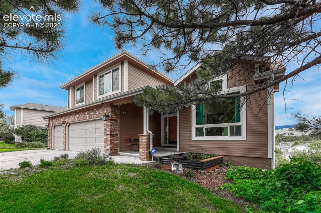 Image 2 of 41: Two-story exterior with horizontal siding and brick accents, featuring a co