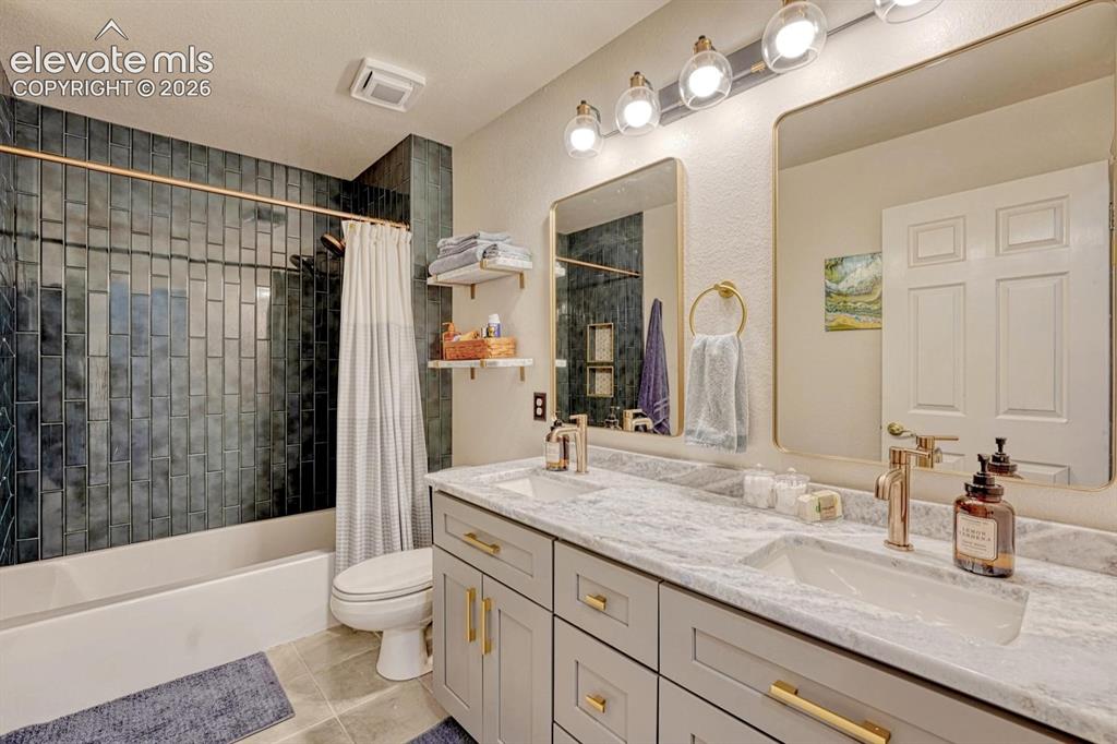 Image 23 of 41: Dual vanity with stone countertop and gold-finish faucets