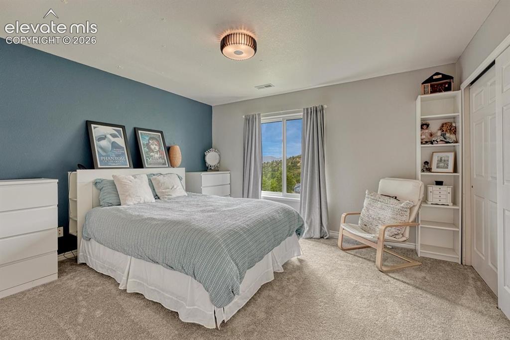 Image 27 of 41: Carpeted flooring, window with exterior scenery, built-in closet with bi-fo