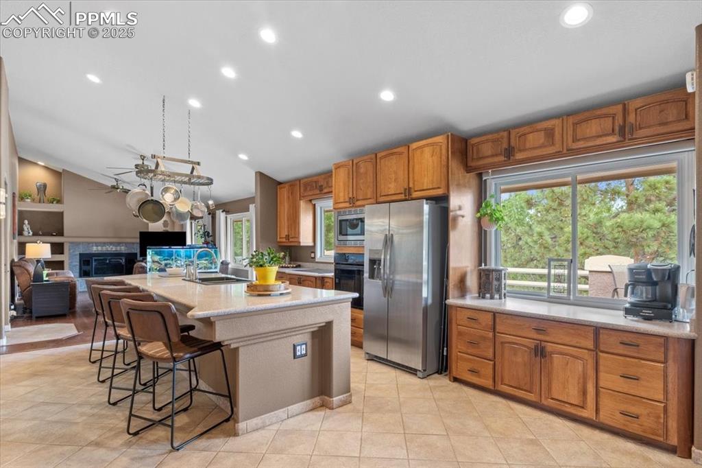 Image 10 of 49: Kitchen with appliances with stainless steel finishes, lofted ceiling, a gl