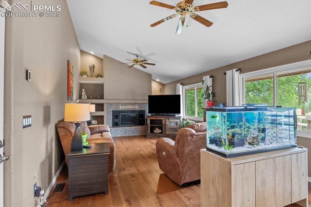 Image 12 of 49: Living area featuring lofted ceiling, ceiling fan, hardwood / wood-style fl