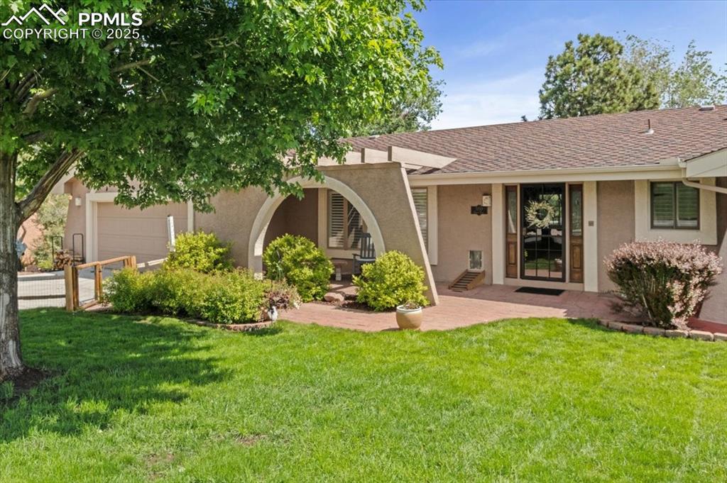 Image 2 of 49: View of front facade with an attached garage, stucco siding, a front yard,