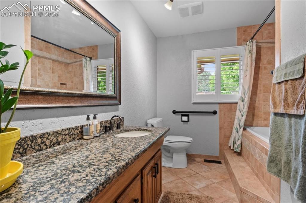 Image 26 of 49: Bathroom featuring tile patterned flooring, healthy amount of natural light