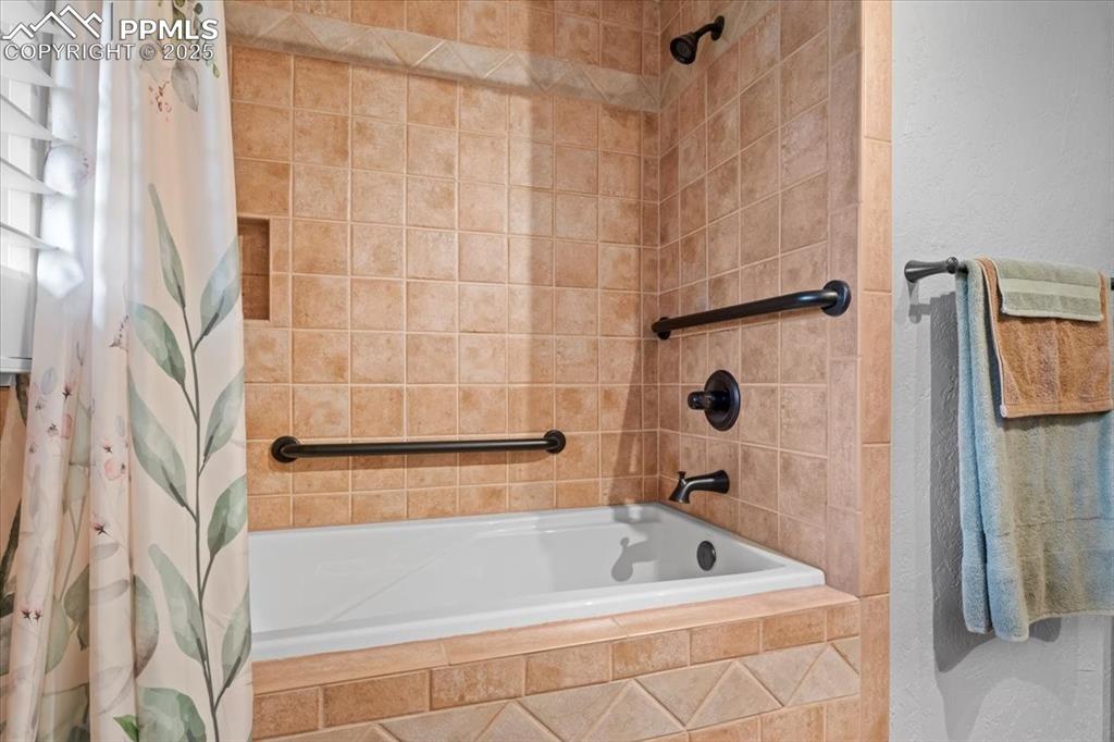 Image 27 of 49: Bathroom featuring tiled shower / bath combo