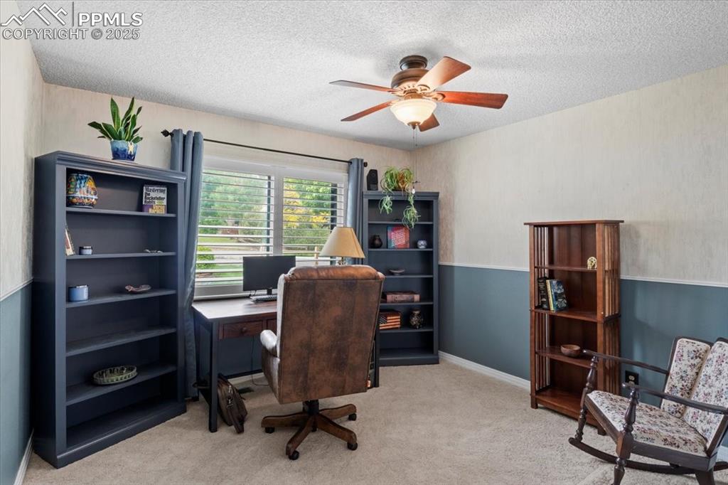 Image 28 of 49: Carpeted office with a textured ceiling and a ceiling fan