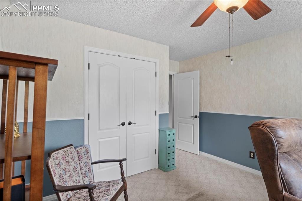 Image 29 of 49: Sitting room featuring a textured ceiling, a ceiling fan, carpet flooring,