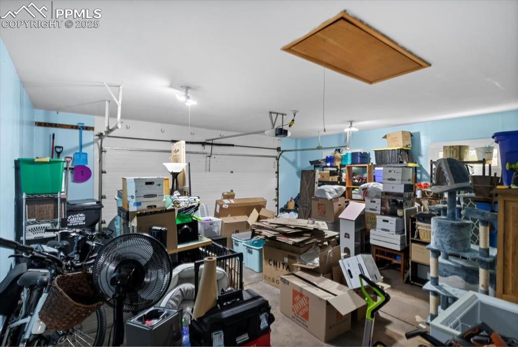 Image 38 of 49: Garage featuring a garage door opener