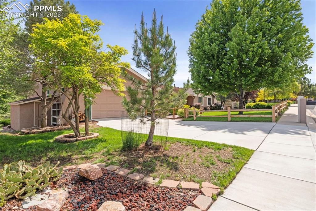 Image 4 of 49: View of front of property with driveway, an attached garage, and stucco sid