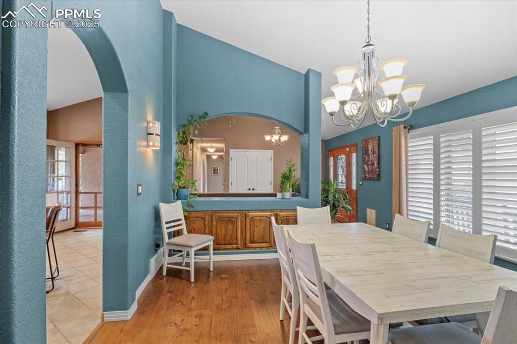 Image 8 of 49: Dining space with a chandelier, arched walkways, healthy amount of natural