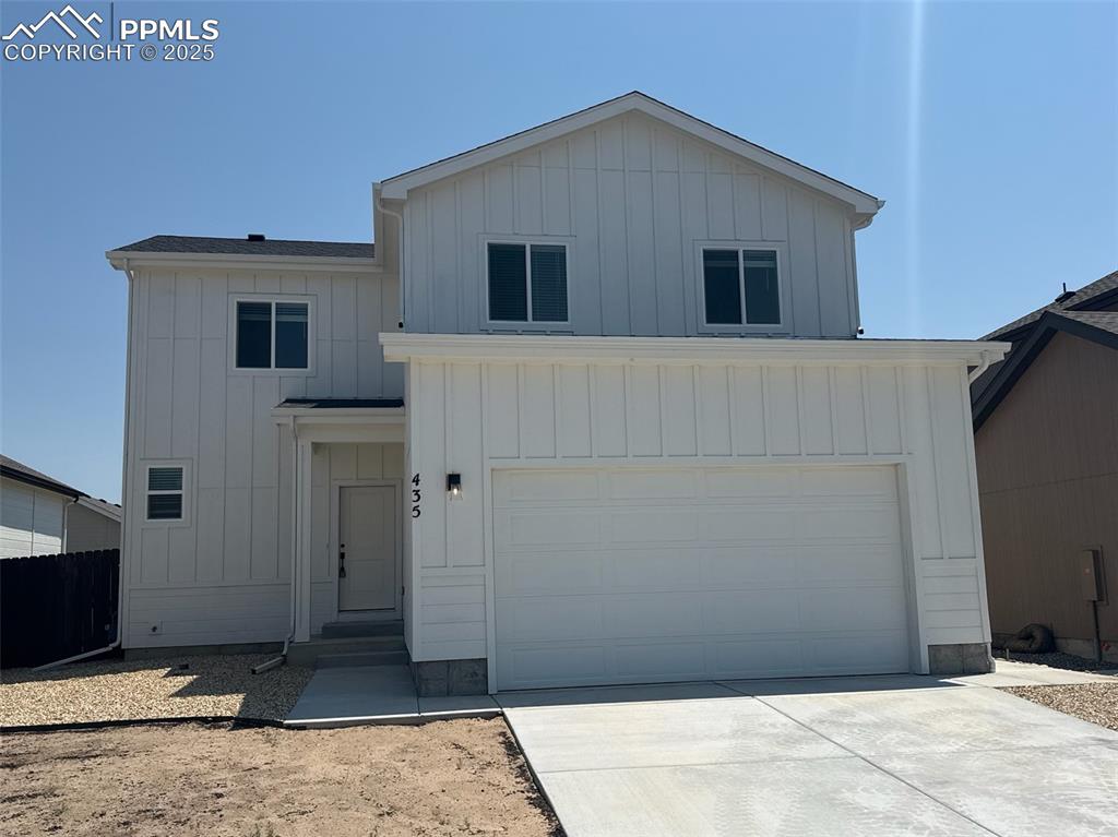 Caption: Modern inspired farmhouse featuring board and batten siding, driveway, and an attached garage