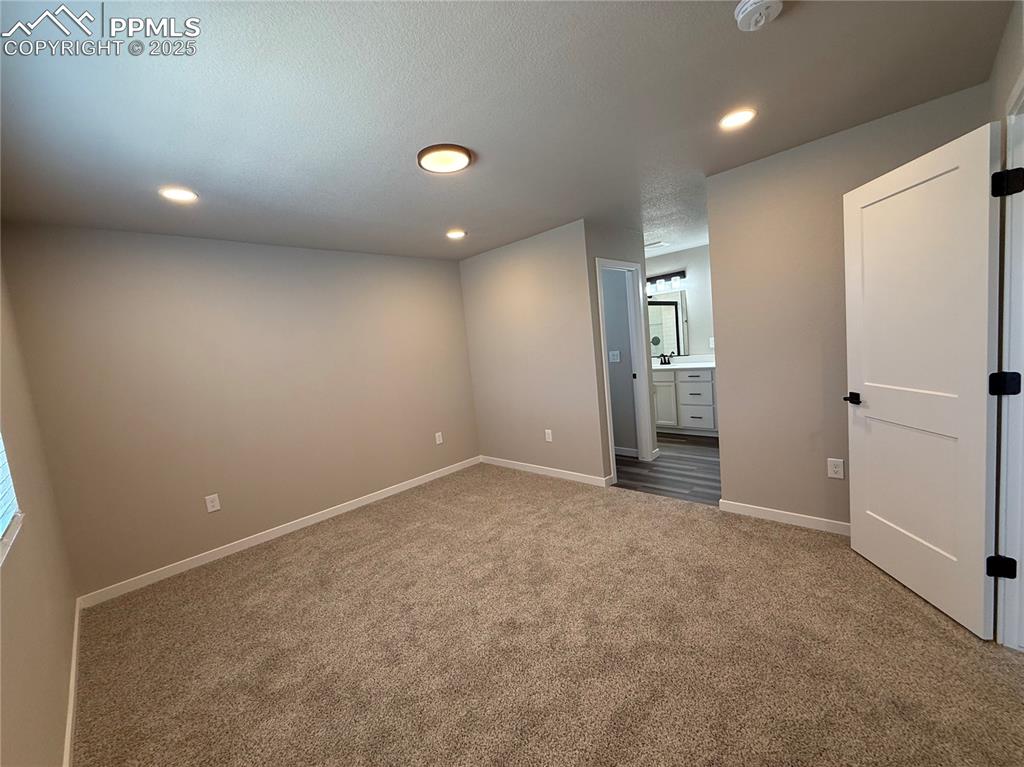 Image 4 of 8: Empty room featuring carpet flooring, recessed lighting, and a textured cei