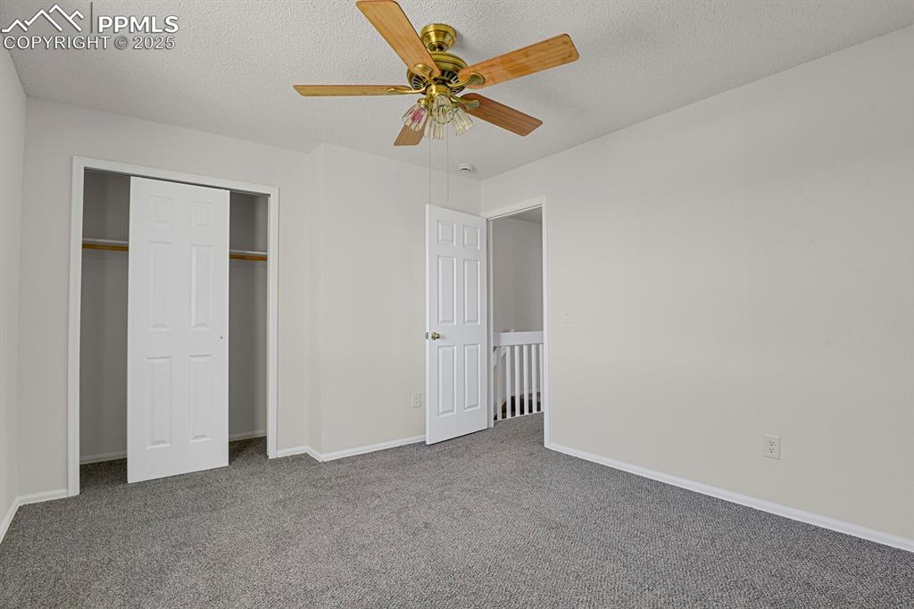 Image 17 of 27: Unfurnished bedroom featuring carpet, a textured ceiling, a closet, and cei