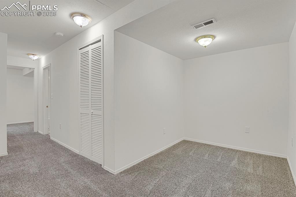 Image 19 of 27: Hall featuring carpet and a textured ceiling