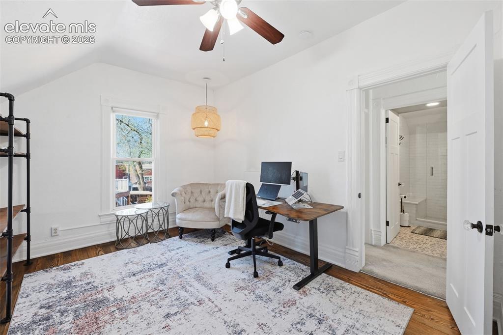 Image 25 of 50: Built-in shelving and
original hardwood
floors in this oversize
bedroom.