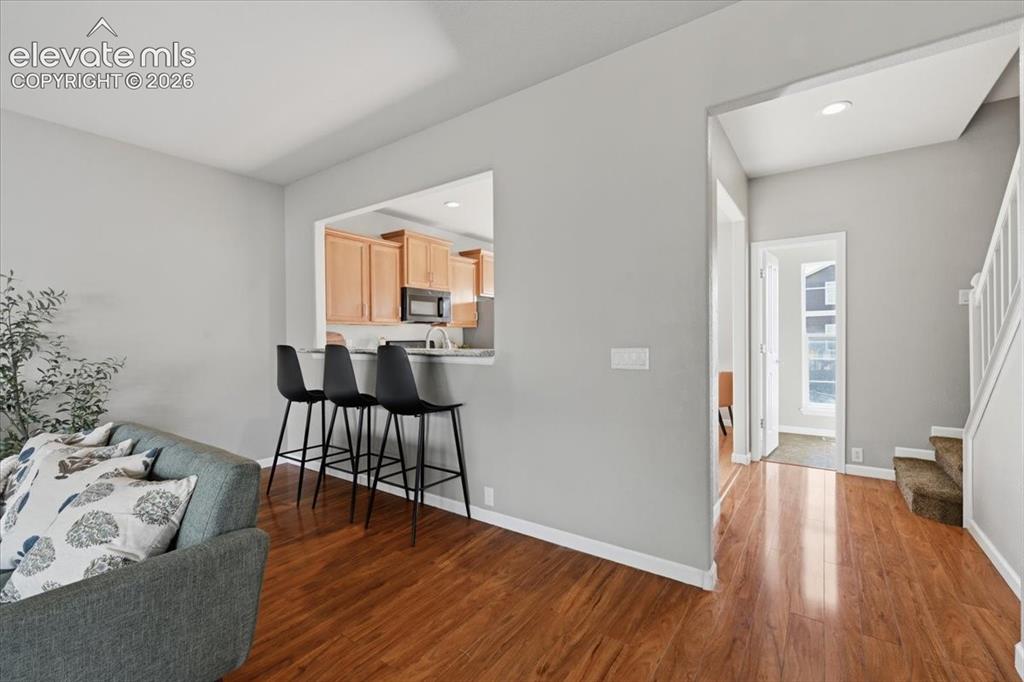 Image 12 of 34: Wood flooring throughout, breakfast bar, natural wood cabinetry.
