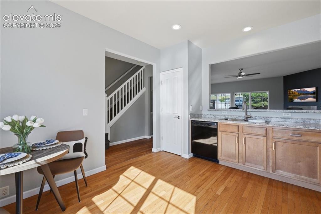 Image 13 of 34: Hardwood flooring, light gray wall paint, white trim, open pass-through, an