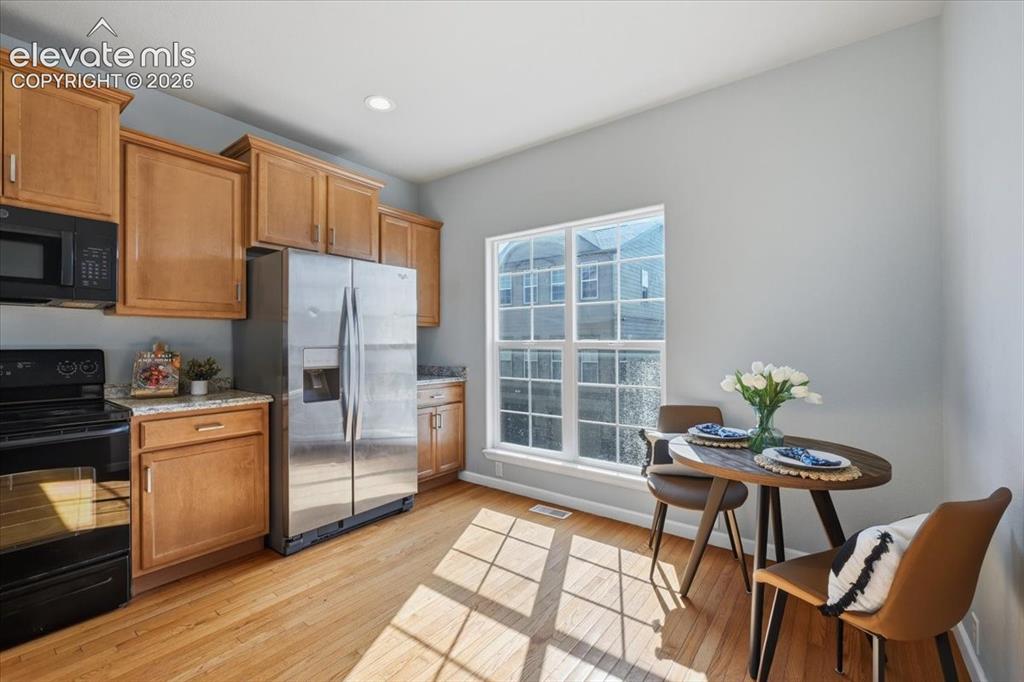 Image 14 of 34: Kitchen space featuring wood flooring, ample cabinetry, and mountain views