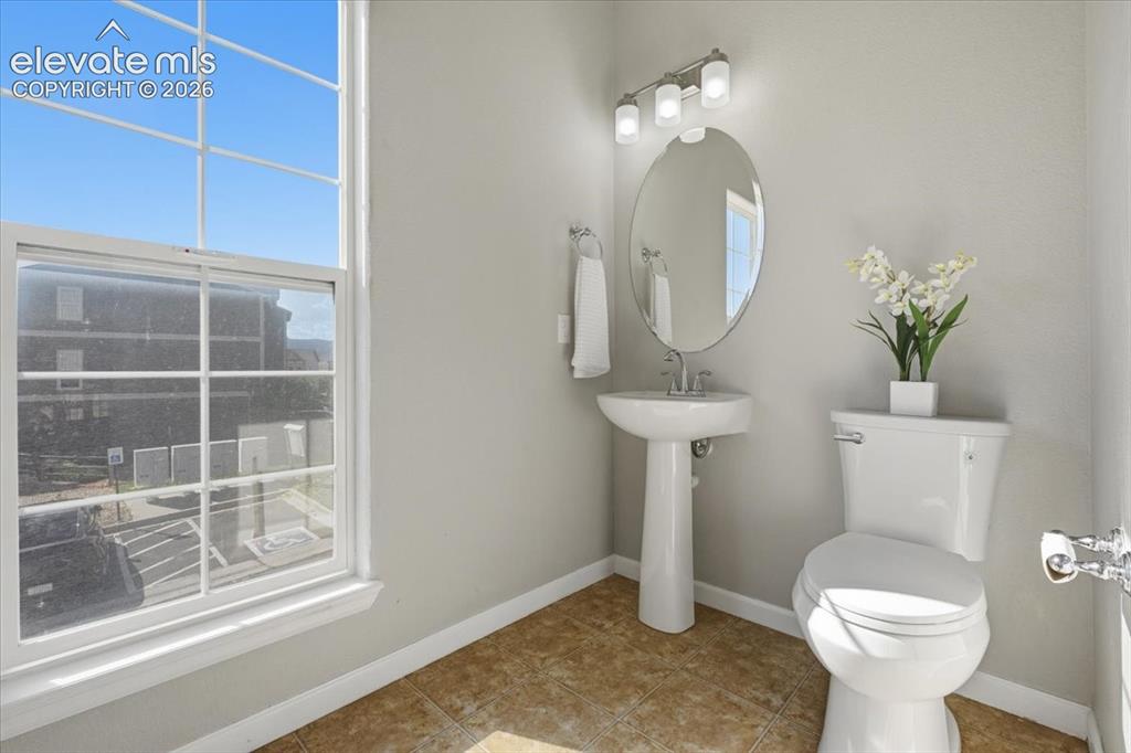 Image 16 of 34: Main level powder room. Pedestal sink, Bright window, flush toilet, and wal