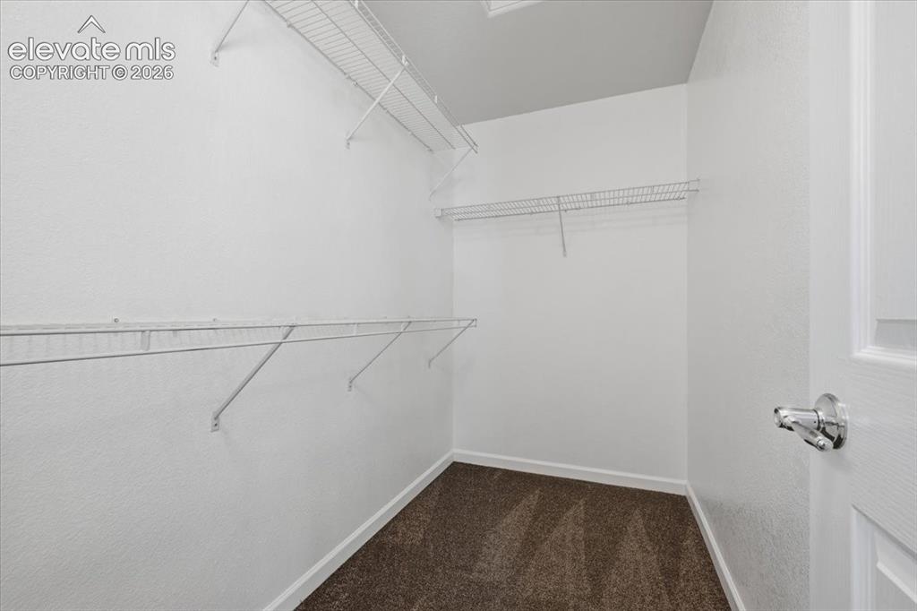 Image 18 of 34: Primary Bedroom Walk-in closet with multiple wire shelving units