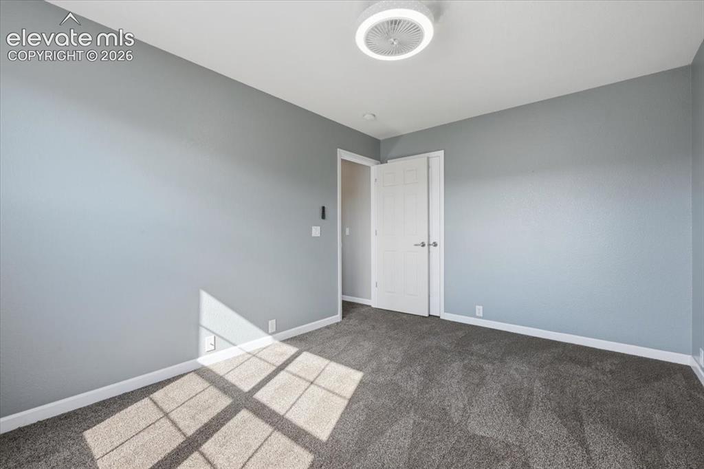 Image 21 of 34: Bedroom 2 - Neutral-toned walls, textured carpet flooring, and a contempora