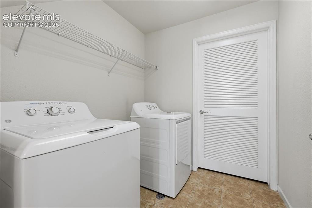Image 24 of 34: First Level Laundry area featuring a top-load washer, a top-load dryer, and