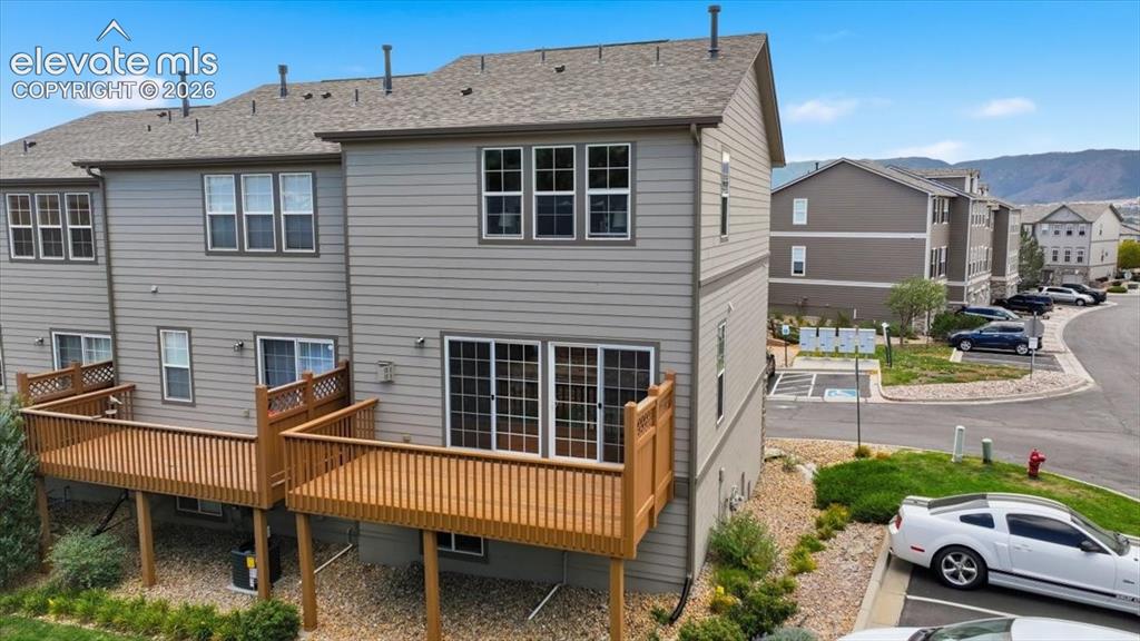 Image 26 of 34: Multi-level property with light siding, private wood decks, and sliding gla