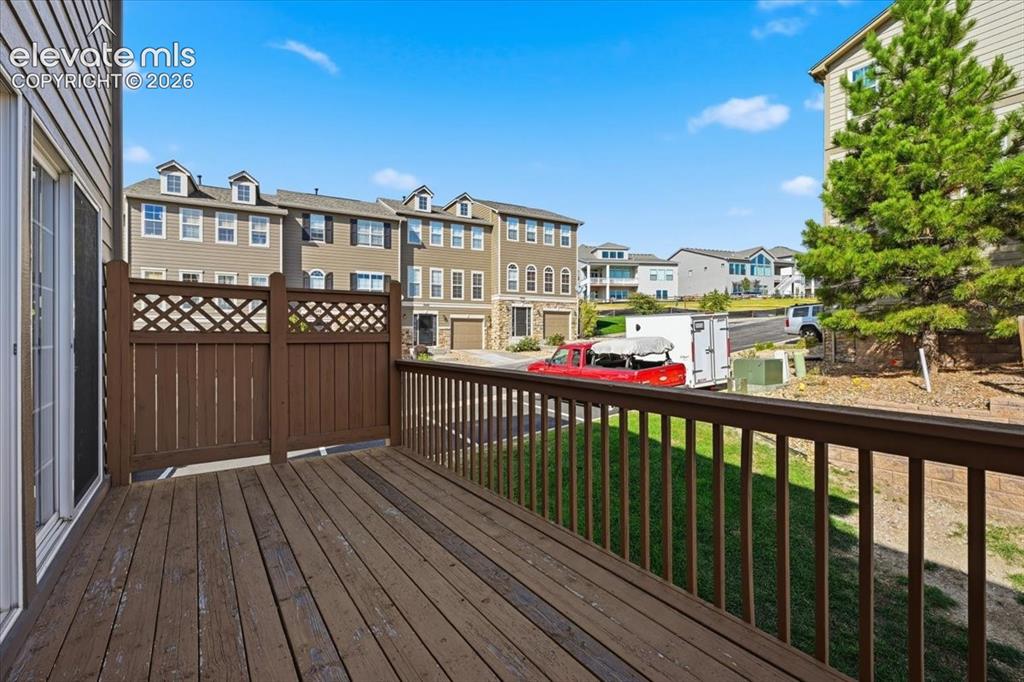 Image 27 of 34: Exterior deck, wood railing, and a privacy screen with lattice detail perfe
