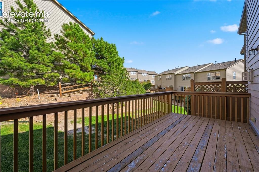 Image 28 of 34: Expansive wooden deck with a lattice privacy panel, surrounded by mature ev