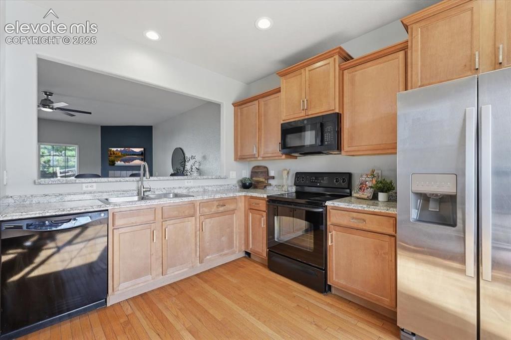 Image 3 of 34: Kitchen featuring wood flooring, wood cabinetry, ample countertops, and a p