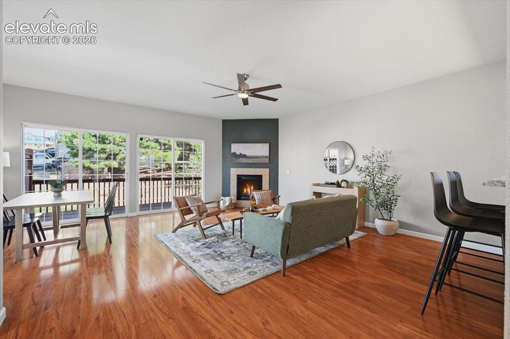 Image 8 of 34: Spacious living area featuring wood flooring, a built-in fireplace with a t