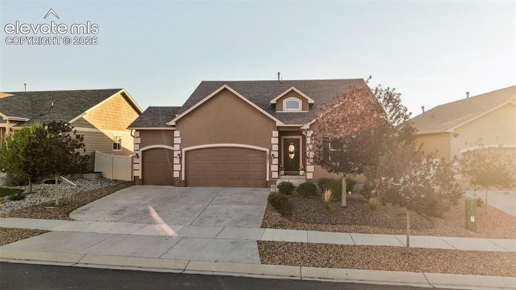 Caption: Stucco exterior with stone accents, attached two-car garage, established landscaping, arched garage 