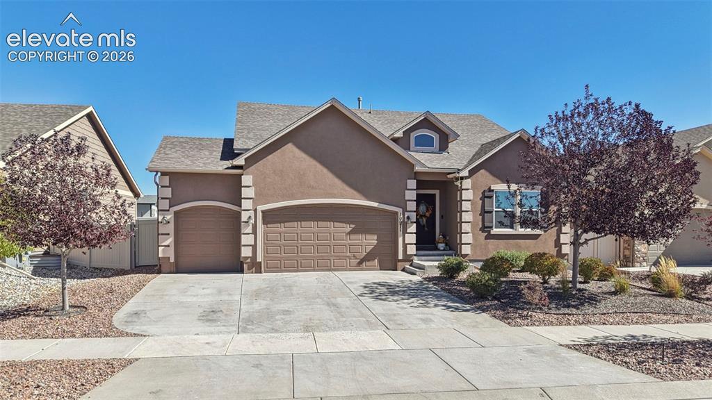 Image 1 of 46: Stucco exterior featuring arched garage entryways, decorative corner quoins