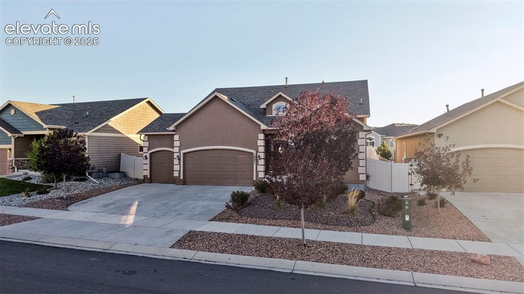 Image 2 of 47: Stucco exterior with an arched entry, attached two-car garage, concrete dri