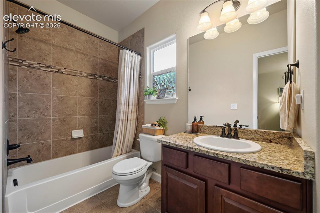 Image 23 of 47: Bathroom featuring a full-size bathtub with tile surround, a built-in vanit