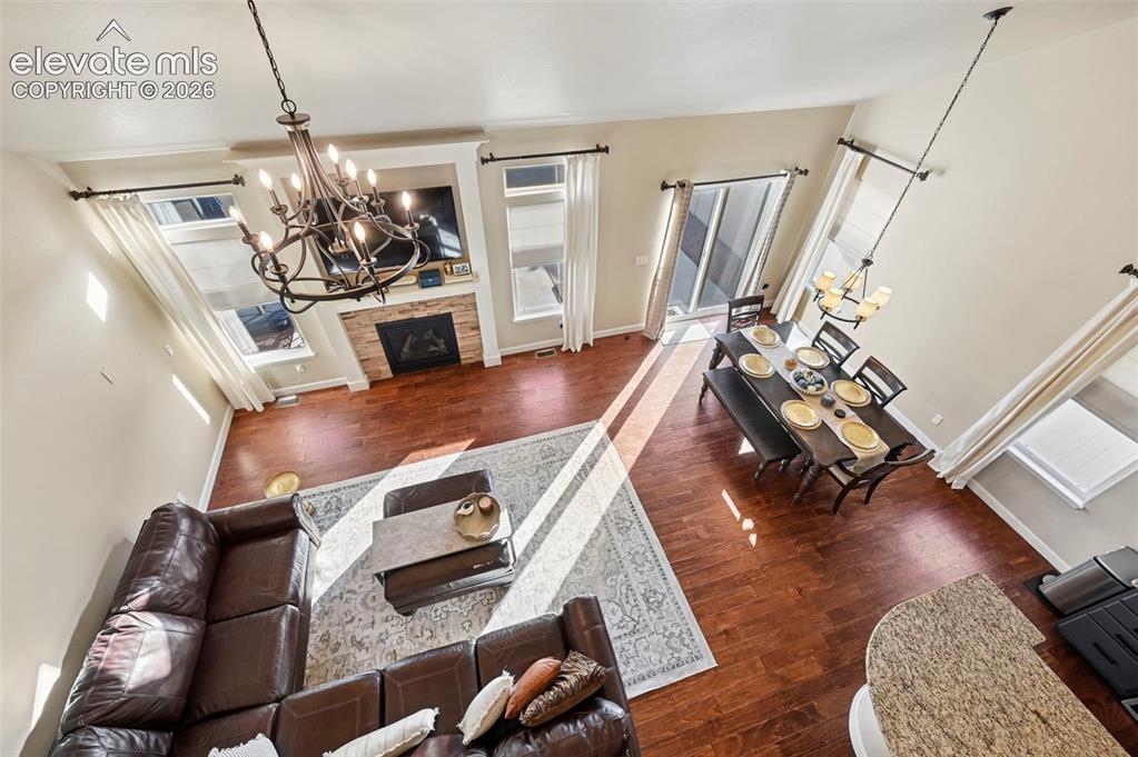 Image 24 of 47: High ceilings with a decorative chandelier, wood-finish flooring, a stone-c