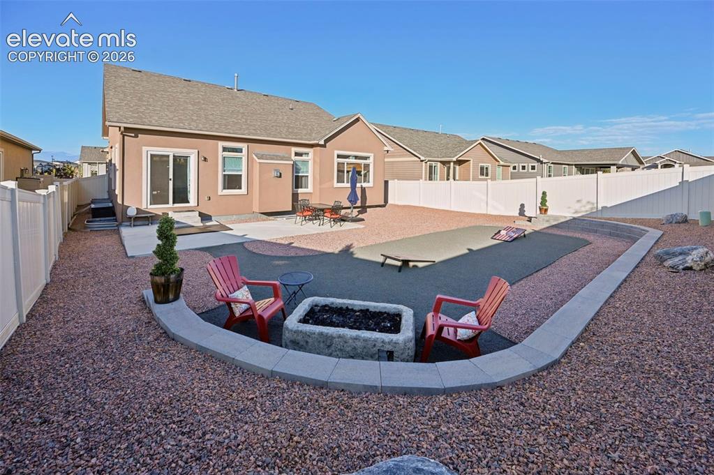Image 36 of 47: Expansive backyard featuring a large patio, built-in fire pit, privacy fenc