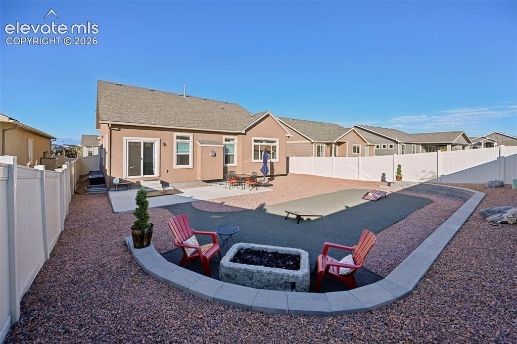 Image 37 of 47: Expansive backyard featuring a gravel landscape, a concrete patio, and a de