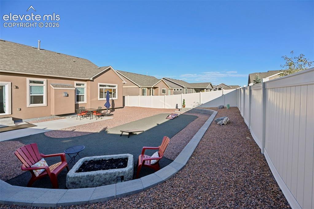 Image 38 of 47: Expansive backyard featuring a built-in fire pit, multiple hardscaped areas