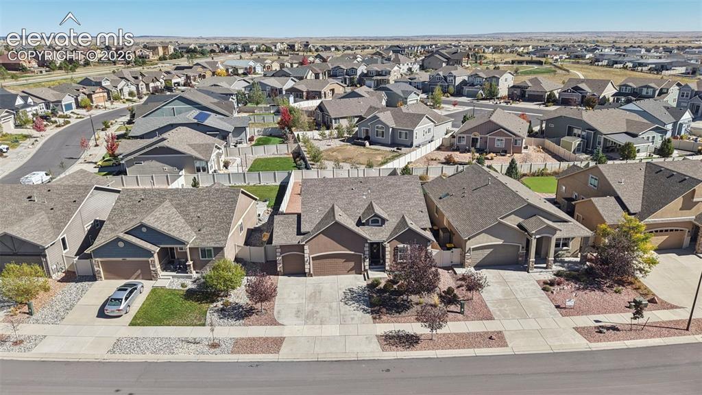 Image 44 of 46: Suburban residential setting featuring multi-gabled rooflines, stone-accent