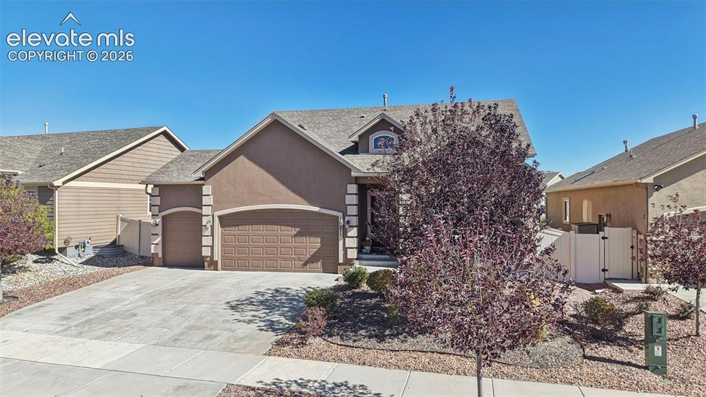 Image 46 of 46: Stucco exterior featuring arched garage openings, quoined corner detailing,