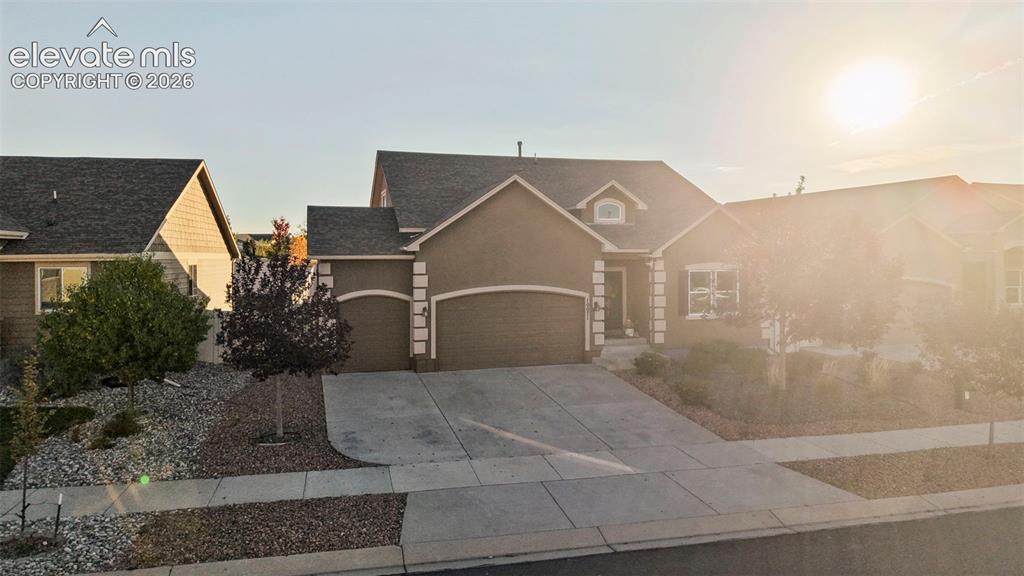 Image 47 of 47: Stucco exterior with decorative trim, arched garage doors, a dormer window,