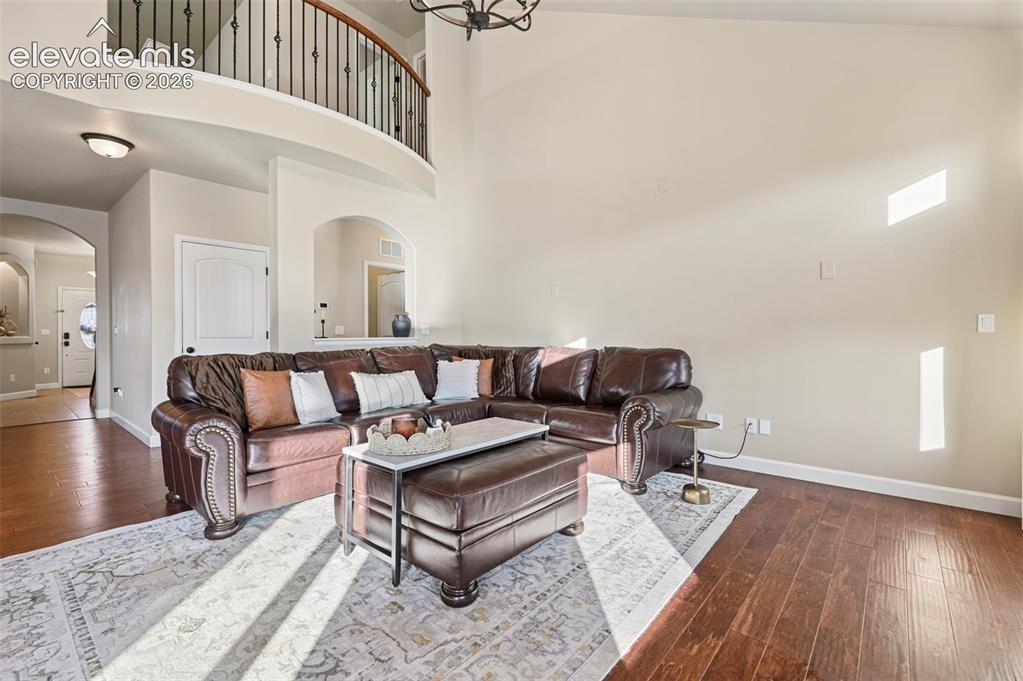 Image 5 of 46: Vaulted ceiling, wood-finish flooring, curved balcony with wrought iron rai